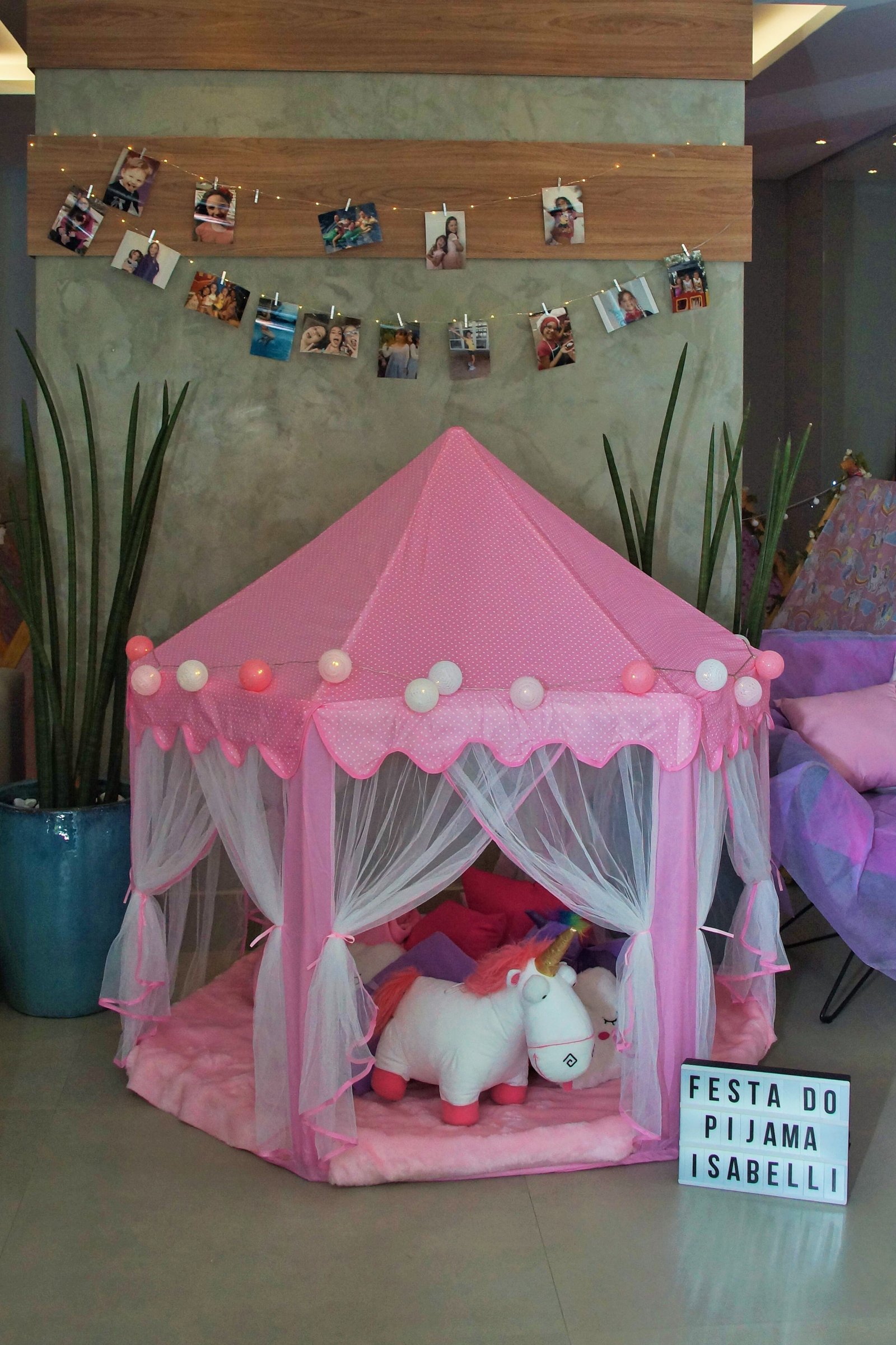 Cabana rosa com luzinhas, almofadas e unicórnio em uma festa do pijama real da Tocaqui Tocacola